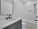 Modern bathroom features a sleek vanity with black fixtures, white tile, and a soaking tub for relaxation at 380 Hillcrest View Dr, Suwanee, GA 30024