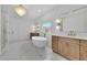 Luxurious bathroom with a soaking tub, double vanity, marble floors and modern chandelier at 380 Hillcrest View Dr, Suwanee, GA 30024