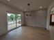 Dining area with paneled accent wall, modern chandelier and sliding glass doors to outdoor deck at 380 Hillcrest View Dr, Suwanee, GA 30024