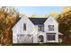 Striking two-story home with painted brick, arched entryway, two-car garage, and dormer windows at 380 Hillcrest View Dr, Suwanee, GA 30024