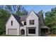 Striking two-story home with painted brick, arched entryway, two-car garage, and dormer windows at 380 Hillcrest View Dr, Suwanee, GA 30024