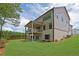 Backyard view of two-story home with a covered deck, brick foundation, and a well-manicured lawn at 380 Hillcrest View Dr, Suwanee, GA 30024