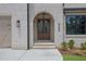 Inviting entryway showcases the archway, wood doors, and manicured shrubbery at 380 Hillcrest View Dr, Suwanee, GA 30024