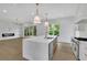 Open kitchen and living area with sleek island, modern appliances, and fireplace at 380 Hillcrest View Dr, Suwanee, GA 30024
