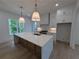Spacious kitchen featuring a large island with quartz countertop, pendant lighting, and modern appliances at 380 Hillcrest View Dr, Suwanee, GA 30024
