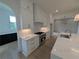 Modern kitchen featuring white cabinets, marble countertops, stainless steel appliances and an archway to another room at 380 Hillcrest View Dr, Suwanee, GA 30024