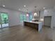 Bright kitchen with an island featuring a marble countertop, a large window, and a sliding glass door to the deck at 380 Hillcrest View Dr, Suwanee, GA 30024