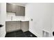 Modern laundry room with gray cabinets, sink, counter space and dark floors at 380 Hillcrest View Dr, Suwanee, GA 30024