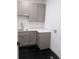 Well-organized laundry room with gray cabinets, white countertops and modern sink at 380 Hillcrest View Dr, Suwanee, GA 30024