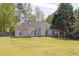 Large backyard with a wooden pergola, green grass, and fenced perimeter at 1635 Round Rd, Grayson, GA 30017