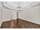 Spacious bedroom featuring dark wood floors, a tray ceiling, and modern light fixture at 1635 Round Rd, Grayson, GA 30017
