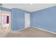 Well-lit bedroom with blue walls, neutral carpet, and doorway to a view of the lavender room at 1635 Round Rd, Grayson, GA 30017