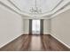 Dining room featuring hardwood floors, tray ceiling, elegant light fixture, and bright window at 1635 Round Rd, Grayson, GA 30017