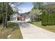 Single-story home with red door and shutters, long driveway, and mature trees at 1635 Round Rd, Grayson, GA 30017