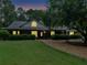 Charming single-story home with manicured lawn, mature trees, and inviting front porch at twilight at 219 Riverbrook Ct, Mcdonough, GA 30252