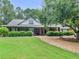 Charming single-story home with manicured lawn, mature trees, and inviting front porch at 219 Riverbrook Ct, Mcdonough, GA 30252