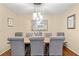 Elegant dining room with a rustic table, upholstered chairs and a modern chandelier at 380 Amberidge Trl, Atlanta, GA 30328