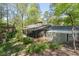 Exterior view of home featuring a screened porch and a wooded backyard at 380 Amberidge Trl, Atlanta, GA 30328