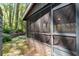Relaxing screened porch with brick foundation and view of the wooded backyard at 380 Amberidge Trl, Atlanta, GA 30328
