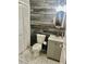 A rustic bathroom with wood paneling and marble floors at 104 Holcomb Ferry Rd, Roswell, GA 30076