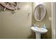 Nautical-themed half-bath with a pedestal sink, decorative accents, and a round mirror at 272 William Nye Se Dr, Atlanta, GA 30315