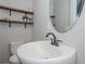 Bathroom featuring a sleek pedestal sink, hardwood shelves, and modern fixtures at 605 Rocky Branch Rd, Villa Rica, GA 30180