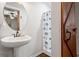 Bathroom featuring pedestal sink, nautical decor shower curtain and barn door at 605 Rocky Branch Rd, Villa Rica, GA 30180