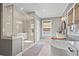 Bright bathroom featuring a glass-enclosed shower, standalone tub, and dual vanities at 7515 Cordery Rd, Cumming, GA 30040