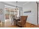 Elegant dining area with a rustic wood table, comfortable seating, and natural light from large windows at 7515 Cordery Rd, Cumming, GA 30040