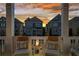 Front porch view showcases cozy seating around a modern fire pit with houses in the background at sunset at 7515 Cordery Rd, Cumming, GA 30040
