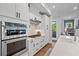 Bright kitchen with a stainless steel oven, gas cooktop, white cabinets, and an adjacent dining area at 7515 Cordery Rd, Cumming, GA 30040