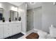 Well-lit bathroom features double sinks, white cabinets, modern shower with glass door, and neutral paint at 1035 Avalon Dr, Lawrenceville, GA 30044