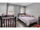 Cozy Bedroom with a crib, bed adorned with plush toys, hardwood floors, and soft gray walls at 1035 Avalon Dr, Lawrenceville, GA 30044