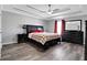 Spacious primary bedroom with tray ceilings, a ceiling fan, neutral gray paint, and modern black furnishings at 1035 Avalon Dr, Lawrenceville, GA 30044