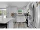 Well-lit kitchen boasts an island, stainless steel appliances, gray backsplash, and white cabinetry, offering modern appeal at 1035 Avalon Dr, Lawrenceville, GA 30044
