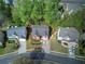 An aerial view showcases three homes with well-maintained lawns and mature trees in a suburban setting at 4111 Mcever Woods Nw Dr, Acworth, GA 30101