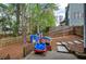 Fenced backyard play area featuring a play house with stepping stone pathway and mature trees at 4111 Mcever Woods Nw Dr, Acworth, GA 30101