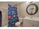 Well-lit bathroom with a dinosaur-themed shower curtain, white vanity, and round mirror at 4111 Mcever Woods Nw Dr, Acworth, GA 30101