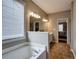 Bright bathroom featuring a soaking tub under a window with blinds and tiled floors at 4111 Mcever Woods Nw Dr, Acworth, GA 30101
