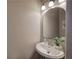Cozy half-bath featuring a pedestal sink, mirror, and modern lighting at 4111 Mcever Woods Nw Dr, Acworth, GA 30101