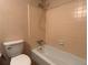 Simple bathroom featuring a shower-tub combo, a toilet, and beige tiled walls at 4152 Scenic Mountain Dr, Snellville, GA 30039