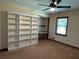 Spacious bedroom with built-in shelving, a ceiling fan, neutral walls, and a window offering natural light at 4152 Scenic Mountain Dr, Snellville, GA 30039