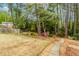 Landscaped backyard with a stone path and a lush backdrop of mature trees at 1152 Old Coach Rd, Stone Mountain, GA 30083