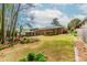 Large backyard with a deck, screen porch, brick exterior, and landscaping at 1152 Old Coach Rd, Stone Mountain, GA 30083
