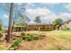 Wide backyard with mature trees, landscaping, a deck, and a screened porch at 1152 Old Coach Rd, Stone Mountain, GA 30083