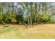 Landscaped backyard with green grass and mature trees at 1152 Old Coach Rd, Stone Mountain, GA 30083
