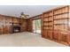 Cozy living room featuring wood paneling, a brick fireplace, built-in shelving, and sliding glass doors at 1152 Old Coach Rd, Stone Mountain, GA 30083