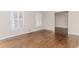 Bright living room featuring hardwood floors, neutral paint, baseboard trim and a view into the dining area at 1152 Old Coach Rd, Stone Mountain, GA 30083