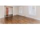 Bright living room featuring hardwood floors, neutral paint, baseboard trim and a view into the dining area at 1152 Old Coach Rd, Stone Mountain, GA 30083