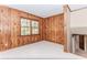 Living room with wood paneling, large windows and white tile flooring at 1152 Old Coach Rd, Stone Mountain, GA 30083